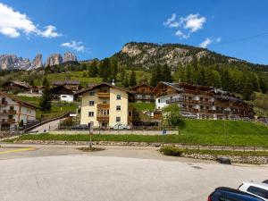a group of buildings in front of a mountain at Appartamento Cuore by AMA Val di Fassa in Campitello di Fassa +2 photos