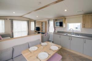 a living room with a table and a kitchen at Cockerham Sands Holiday Park in Cockerham