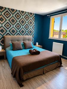 a bedroom with a large bed with blue walls at "L Eden enchanté" Chambres d'hôtes et Bulle d'Eden Spa Massages Boucau Côte Basque in Boucau
