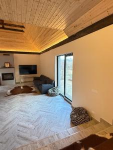 a large living room with a couch and a ceiling at Blue Moon in Zărneşti