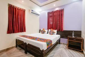 a bedroom with a bed and red curtains at Via Sagar Darshan in Panaji