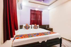 a bedroom with a large bed with red curtains at Via Sagar Darshan in Panaji
