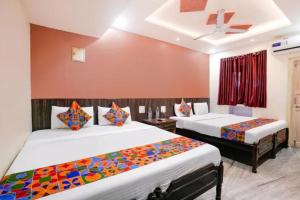 two beds in a room with red walls at Via Sagar Darshan in Panaji