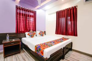 a bedroom with a bed and red curtains at Via Sagar Darshan in Panaji