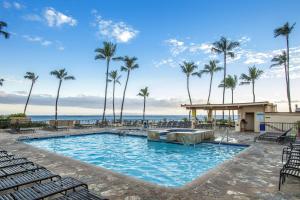 a pool at the beach with palm trees at SUGAR BEACH RESORT, #PH27 in Kihei