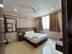 a bedroom with a large bed and a mirror at Shore Appartments in Udupi