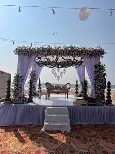 a wedding arch with a bench and a table at Shore Appartments in Udupi +29 photos