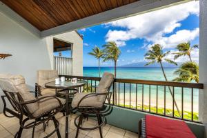 a balcony with a table and chairs and the ocean at Hale Mahina #B-405 in Honokowai
