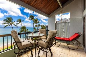 a balcony with a table and chairs and the ocean at Hale Mahina #B-405 in Honokowai