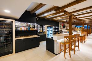 a bar with black cabinets and bar stools at Hotel Selsky Dvur in Vyškov
