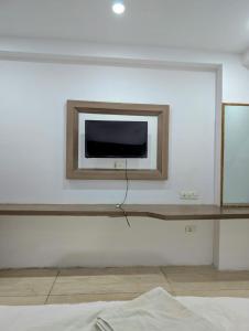 a tv on a white wall in a room at Classic Hotel in Pānīpat