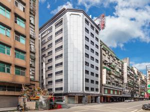 a tall white building on a city street at Doitsu Hotel in Taipei