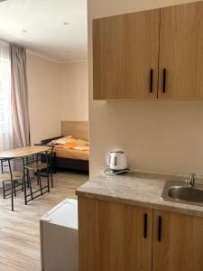 a kitchen with a sink and a room with a bed at Pokoje Blisko Morza SUNSET in Ustka