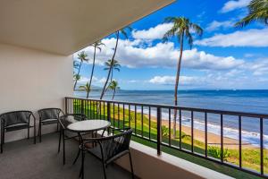 a balcony with a table and chairs and a view of the ocean at SUGAR BEACH RESORT, #235 in Kihei