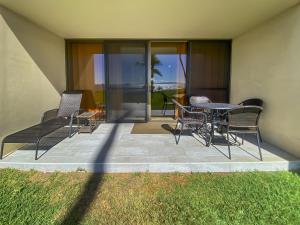 a patio with chairs and a table and glass doors at SUGAR BEACH RESORT #125 in Kihei