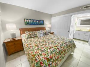 a bedroom with a bed with a floral bedspread at SUGAR BEACH RESORT #125 in Kihei