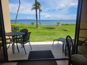 a patio with a table and chairs and the ocean at SUGAR BEACH RESORT #125 in Kihei