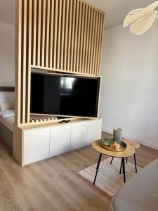 a living room with a large flat screen tv at Kaszmir Studio in Tarnowskie Góry