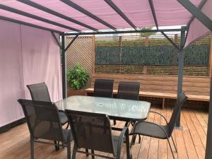 a table and chairs under a pergola in a patio at Oasis de la rivière in Saguenay