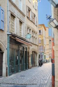 a cobblestone street in a city with buildings at La suite du Brésil - Centre historique du Puy in Le Puy-en-Velay