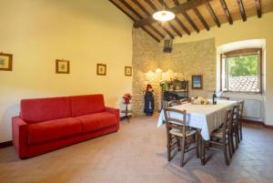 a living room with a red couch and a table at Agriturismo I Melograni in Ferentillo
