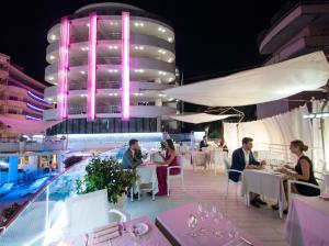 a restaurant on the roof of a building with people sitting at tables at Hotel Premier & Suites - Premier Resort in Milano Marittima +99 photos