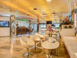 a salon with white chairs and tables in a room at Hotel Premier & Suites - Premier Resort in Milano Marittima