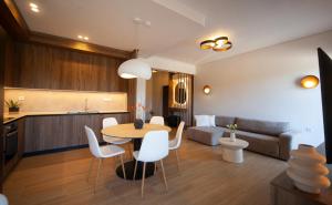a kitchen and a living room with a table and chairs at Arcadian Design Loft in Tripoli