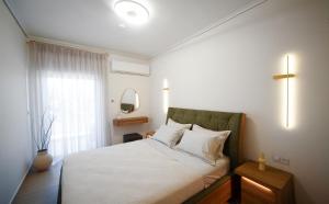 a bedroom with a white bed with a window at Arcadian Design Loft in Tripoli