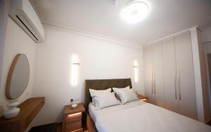 a small bedroom with a bed and a mirror at Arcadian Design Loft in Tripoli