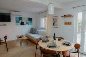 a living room with a table and a couch at Kalumi Aparthotels - Japandi-Style Apartments with Terrace, Pergola, and Portuguese BBQ in Vila Nova de Milfontes