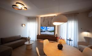 a living room with a table and a television at Arcadian Design Loft in Tripoli +9 photos