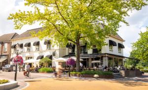 a street scene with people sitting outside a building at De Zwaan Delden in Delden