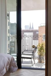 a bedroom with a view of a balcony at Hotel Montaigne in Ostend
