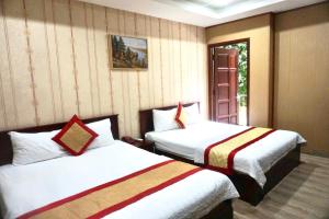 a hotel room with two beds and a window at Hoa Sua Hotel in Vung Tau