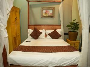 a bedroom with a canopy bed with white sheets and pillows at The Tree Resort in Malavli +58 photos
