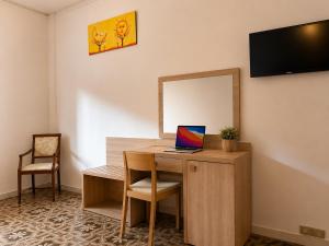 a desk with a laptop on it with a mirror at Hotel Cristallo - Chianciano Terme in Chianciano Terme