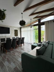 a living room with couches and a table and chairs at Mon Resort by Ana1St in Scărişoara