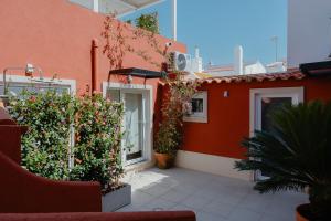 a building with plants and flowers on the side of it at Kalumi Aparthotels - Japandi-Style Apartments with Terrace, Pergola, and Portuguese BBQ in Vila Nova de Milfontes