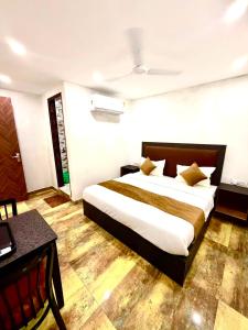 a bedroom with a bed and a desk in a room at Hotel Vasundhara Villa - Greater Kailash in New Delhi