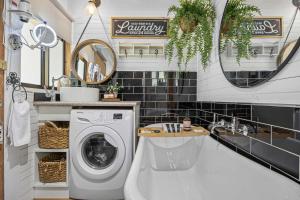 a bathroom with a washing machine and a sink at Cedar Country Retreat in Halls Gap +30 photos