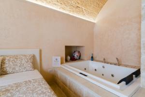 a bath tub in a room with a bed at Corte Donato Grasso Relax - Salento Selection in Alessano
