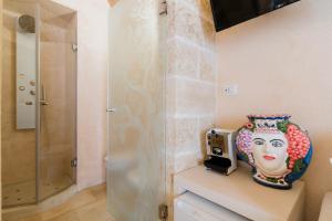 a vase sitting on a shelf next to a shower at Corte Donato Grasso Relax - Salento Selection in Alessano +34 photos