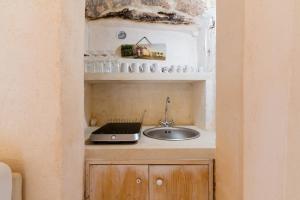a kitchen with a sink and a laptop on a counter at Corte Donato Grasso Relax - Salento Selection in Alessano
