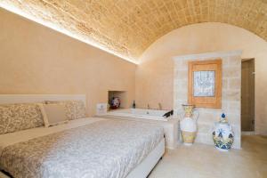 a bedroom with a bed and a bath tub at Corte Donato Grasso Relax - Salento Selection in Alessano