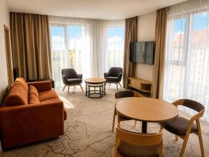 a living room with a couch and chairs and a tv at Tower Hotel Wrocław in Wrocław