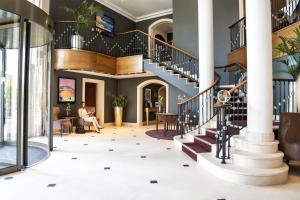 eine Lobby mit Wendeltreppe in einem Gebäude in der Unterkunft Maison Messmer - ein Mitglied der Hommage Luxury Hotels Collection in Baden-Baden