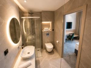a bathroom with a shower and a toilet and a sink at Tower Hotel Wrocław in Wrocław
