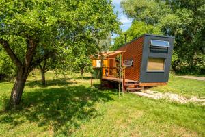 a tiny house in a field with a tree at Ráj pod Troskami in Semily