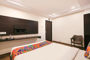 a bedroom with a bed and a tv on the wall at FabHotel Excella Vizag in Visakhapatnam